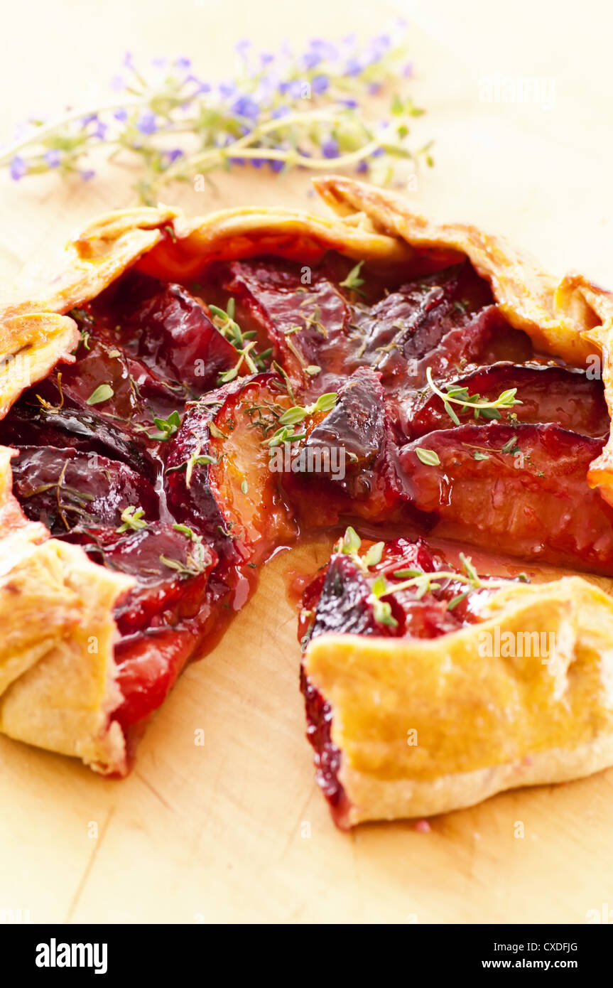 Tart with plums and fresh herbs Stock Photo