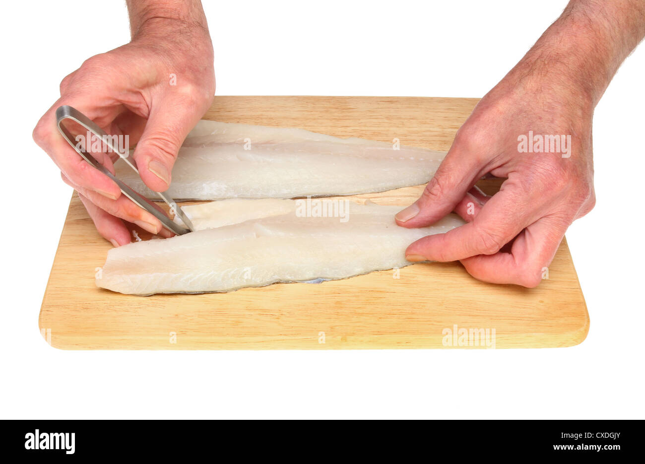 Hands pin boning fish fillets on a wooden board isolated against white Stock Photo