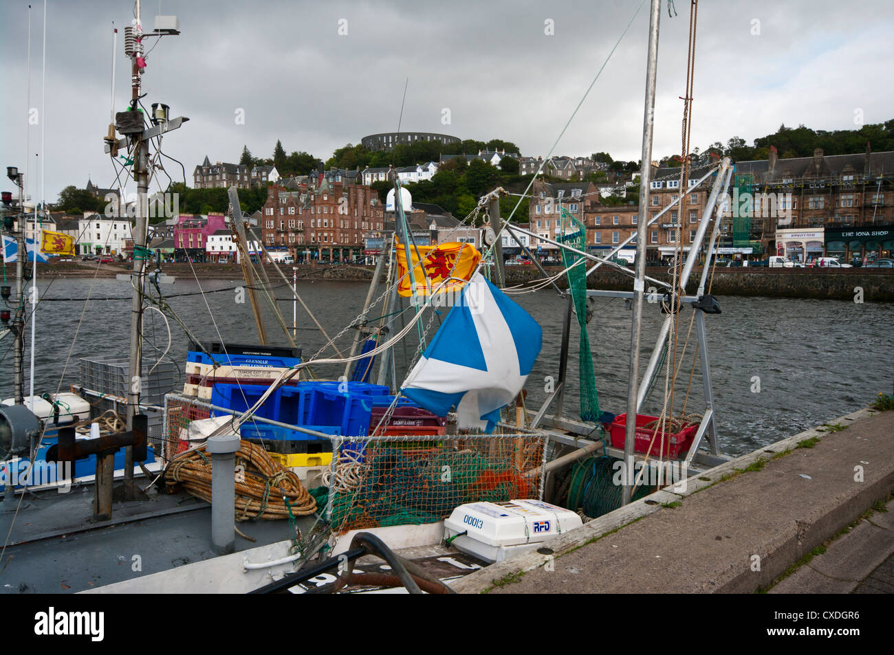 Scottish Flag Flags On Fishing Boats With The Town of Oban Argyll and Bute Scotland In The Background Stock Photo