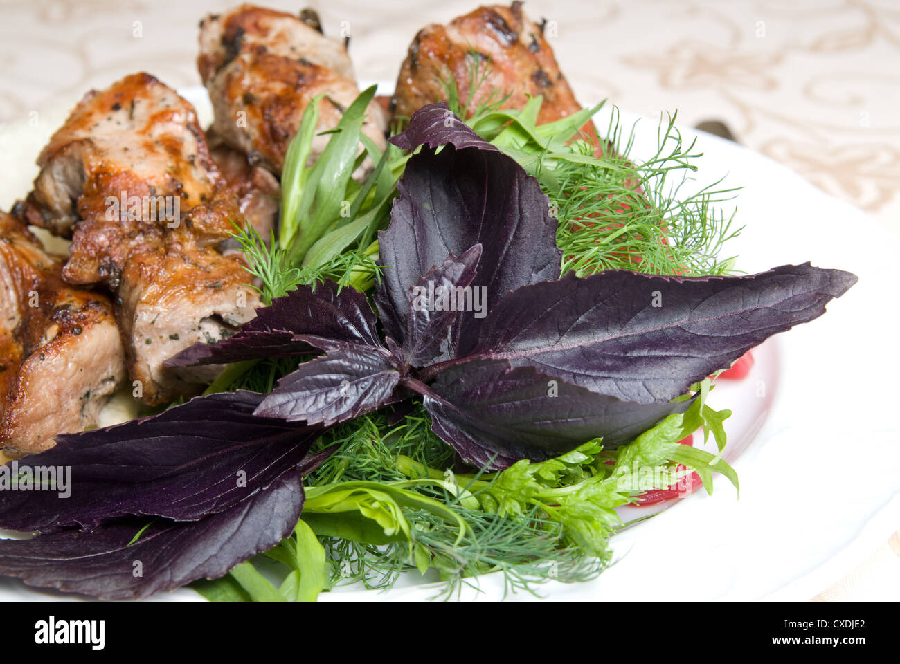 fried meat with potherbs on the plate Stock Photo