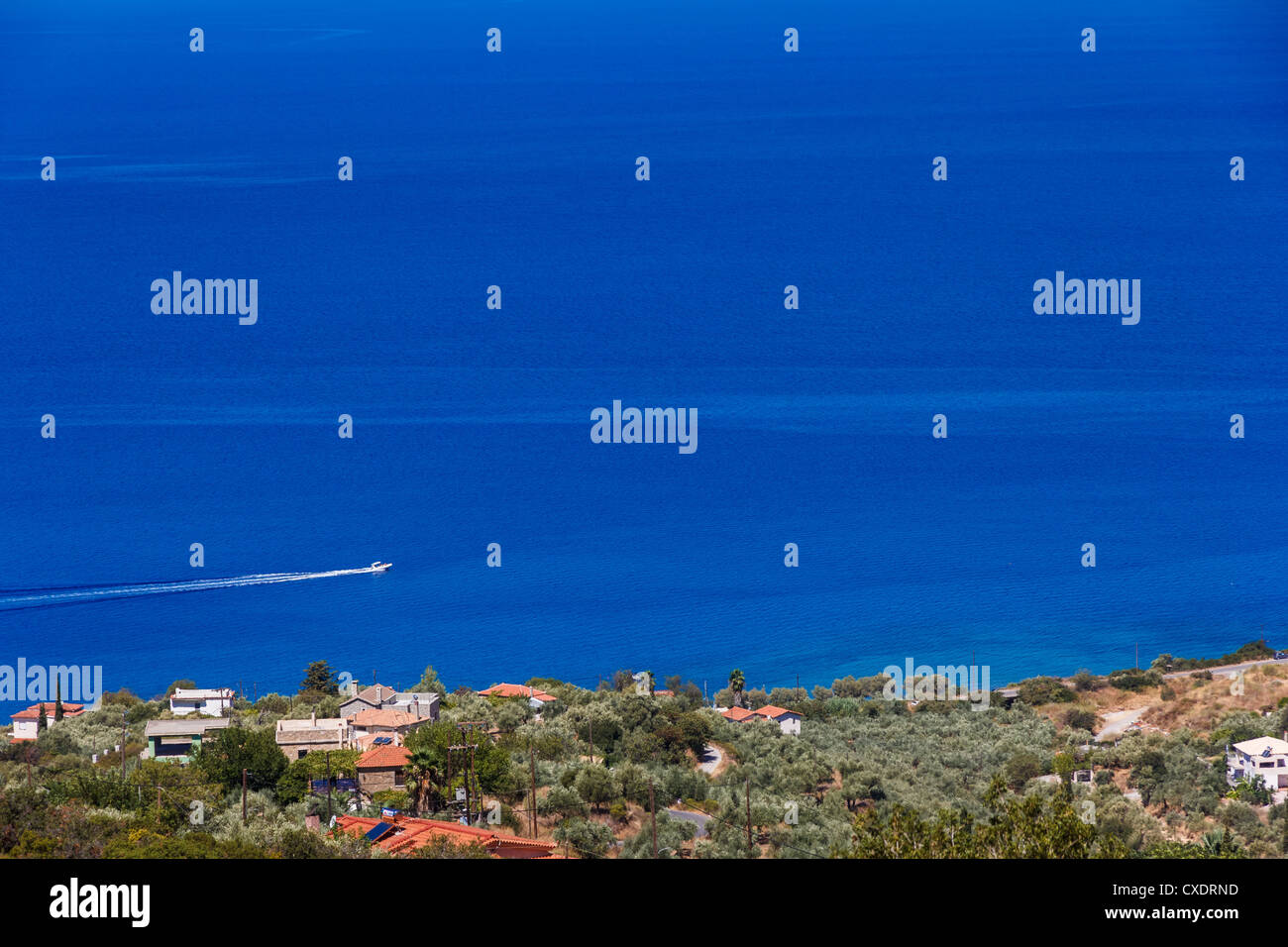 Small boat traveling at sea, shot from a high point of view in Greece Stock Photo