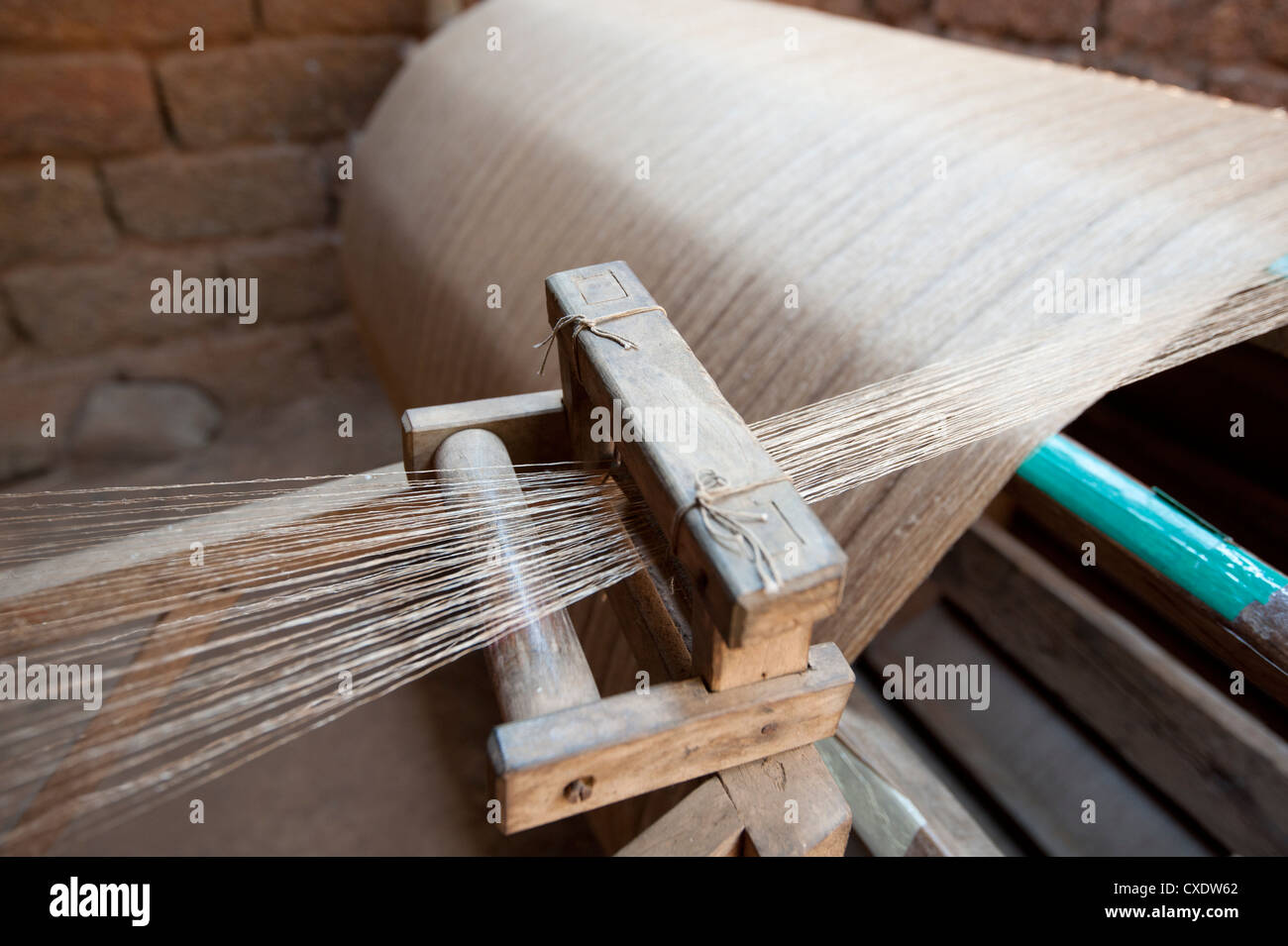 Silk thread being spun on large handmade wooden wheel, rural Orissa, India, Asia Stock Photo