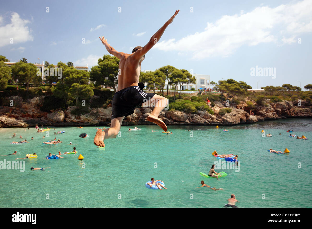 Cala D'Or, a boy jumps into the water Stock Photo