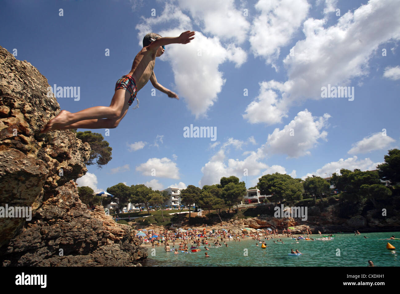Cala D'Or, teenager jumps from a cliff into water Stock Photo - Alamy