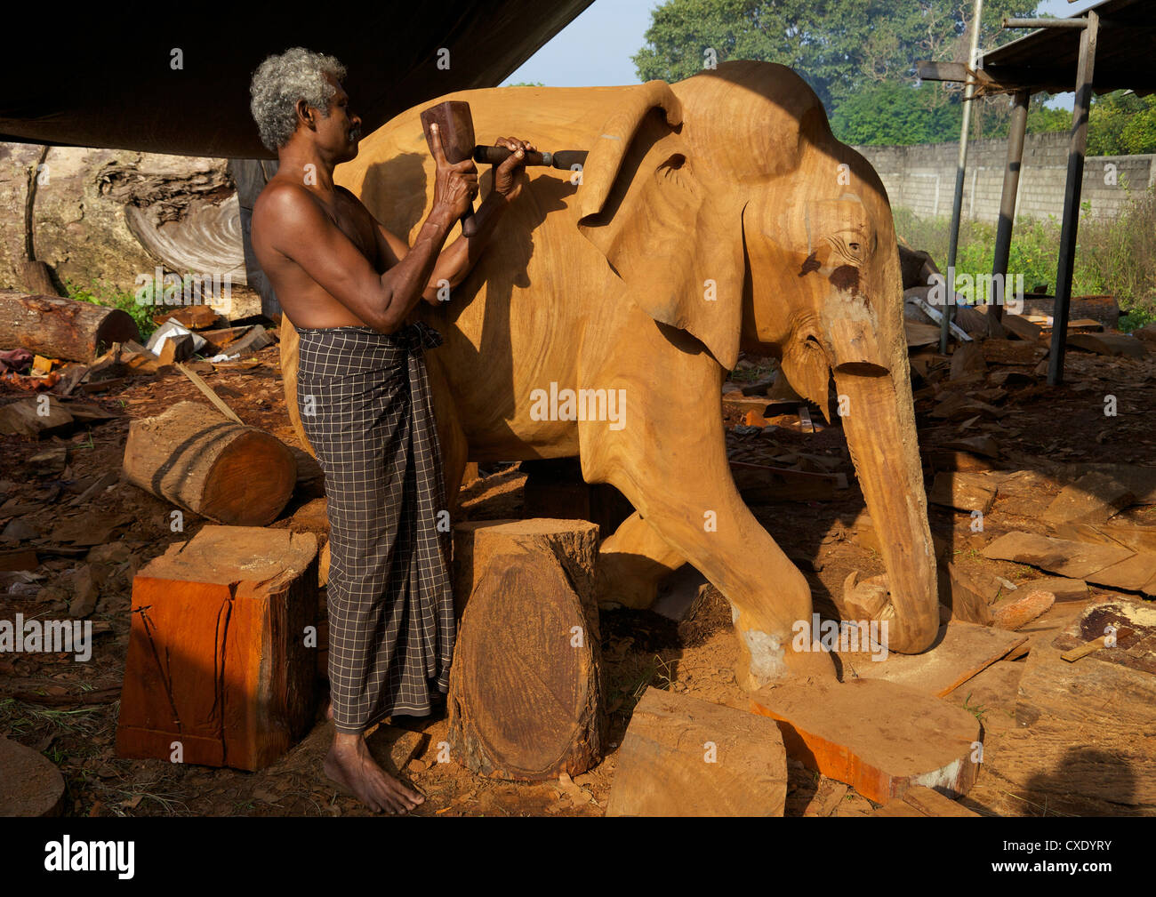 Sri Lankan wood carver making wooden statue of asian elephant, The