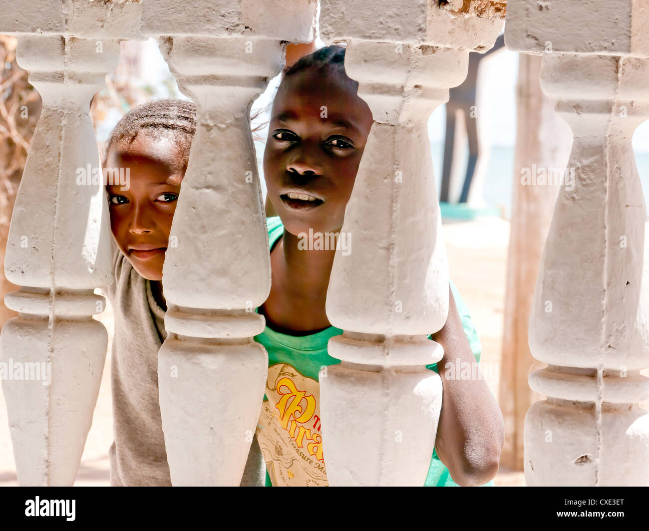 Two young boys looking through balustrades on the Island of Albreda, Gambia Stock Photo