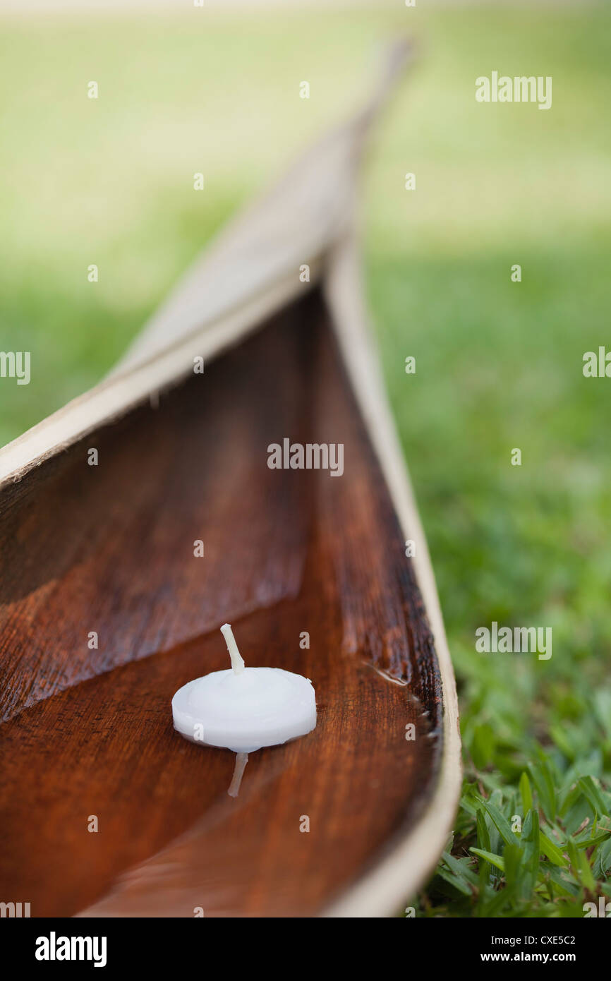 Votive candle floating in water cupped within palm leaf Stock Photo Alamy