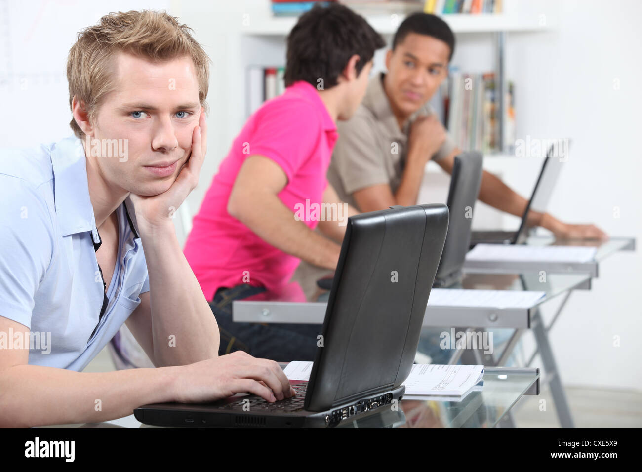 A student in the library with his laptop Stock Photo - Alamy