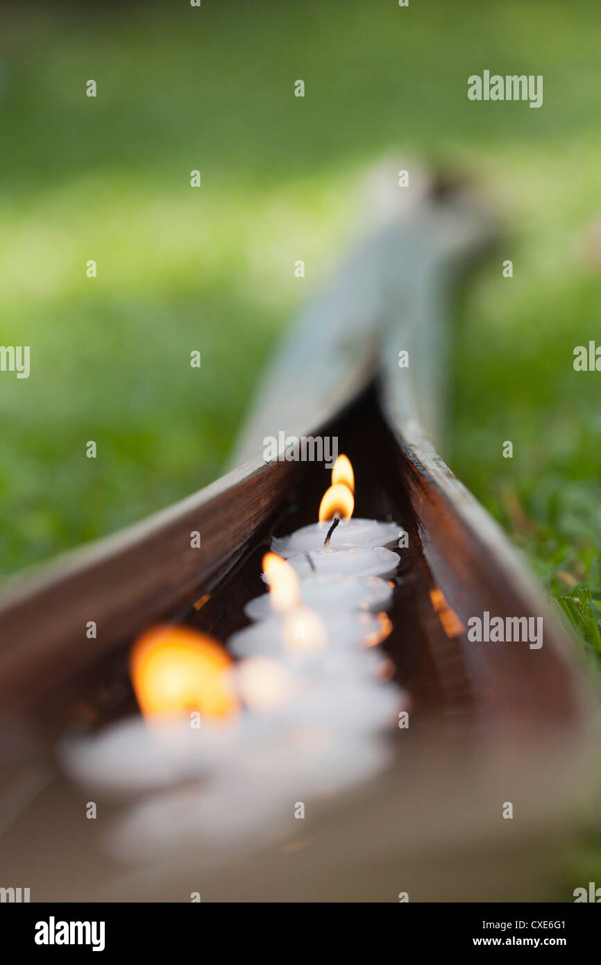 Lit votive candles floating in water cupped within palm leaf Stock Photo Alamy