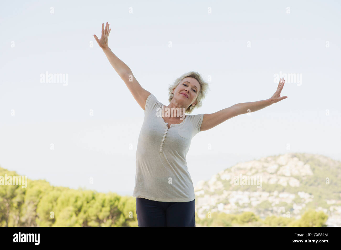 Mature woman exercising with arms outstretched Stock Photo - Alamy