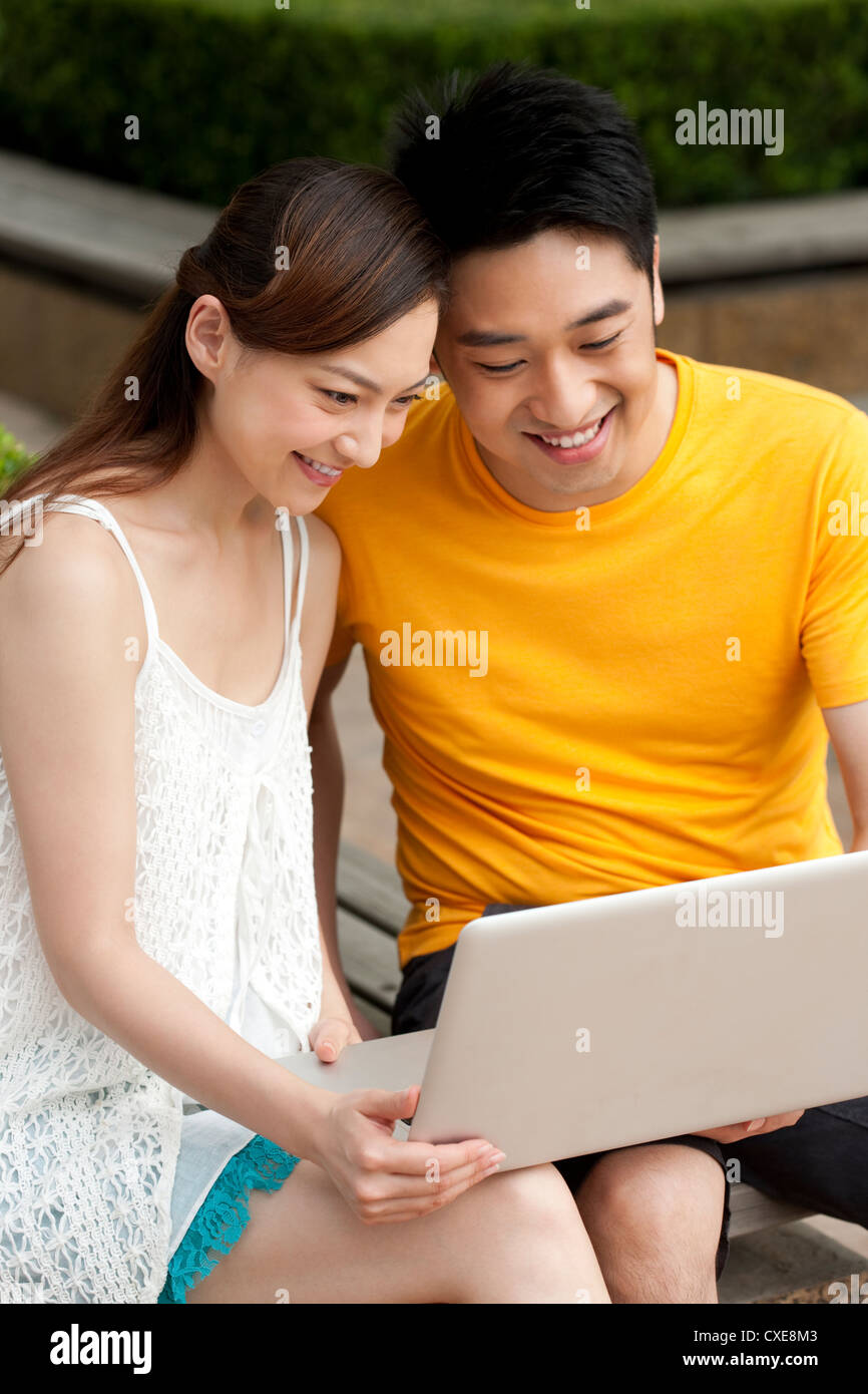 Young couple using laptop outdoors Stock Photo - Alamy