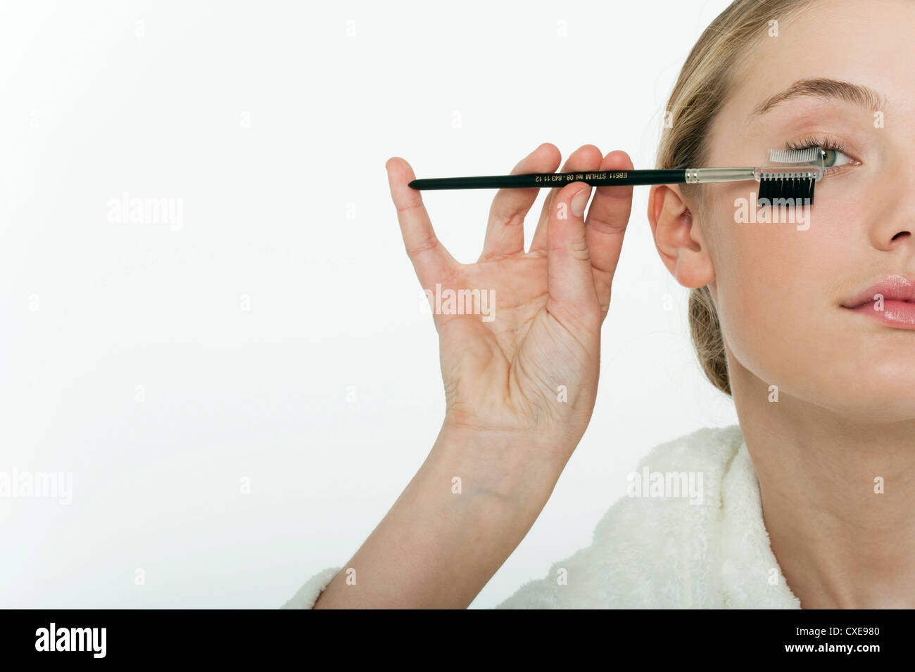 Preteen girl brushing her eyelashes, cropped Stock Photo
