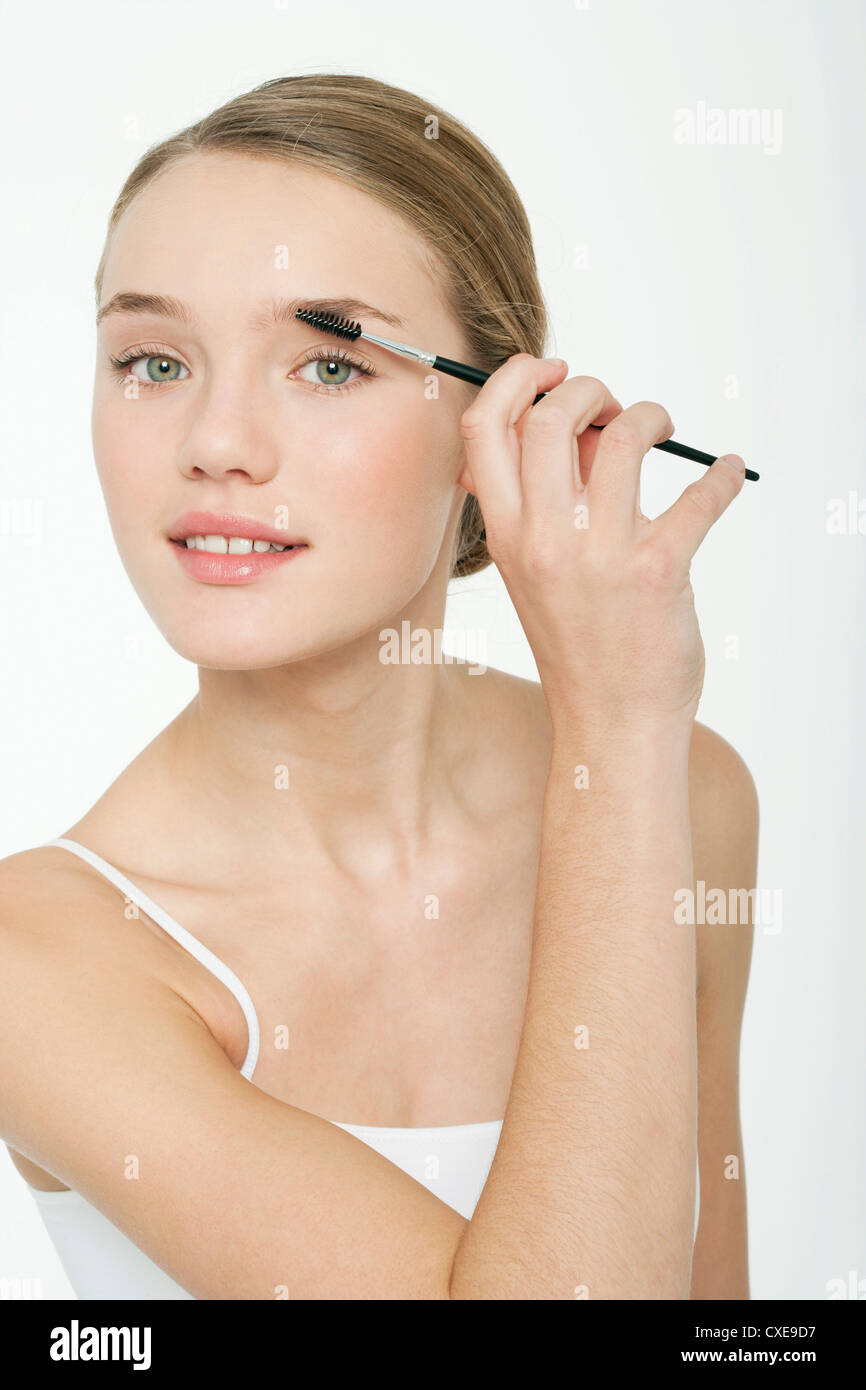 Preteen girl using eyebrow brush Stock Photo
