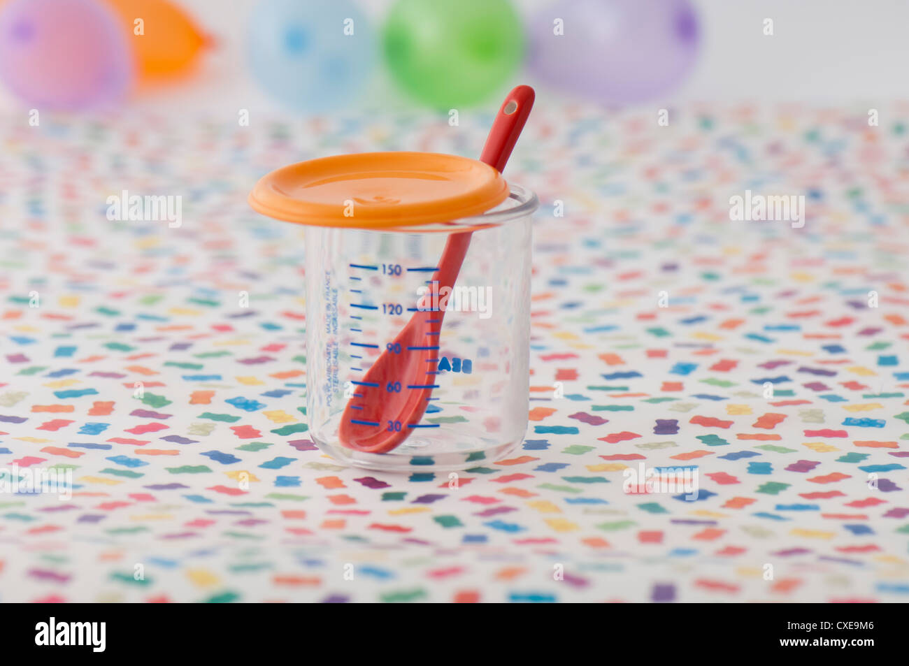 Plastic measuring cup and baby spoon Stock Photo