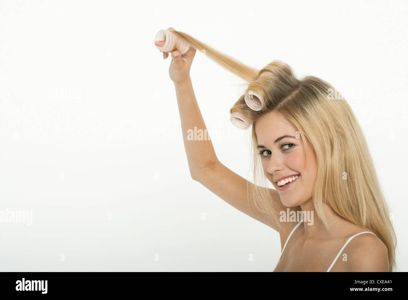 Teen girl rolling her hair with curlers Stock Photo