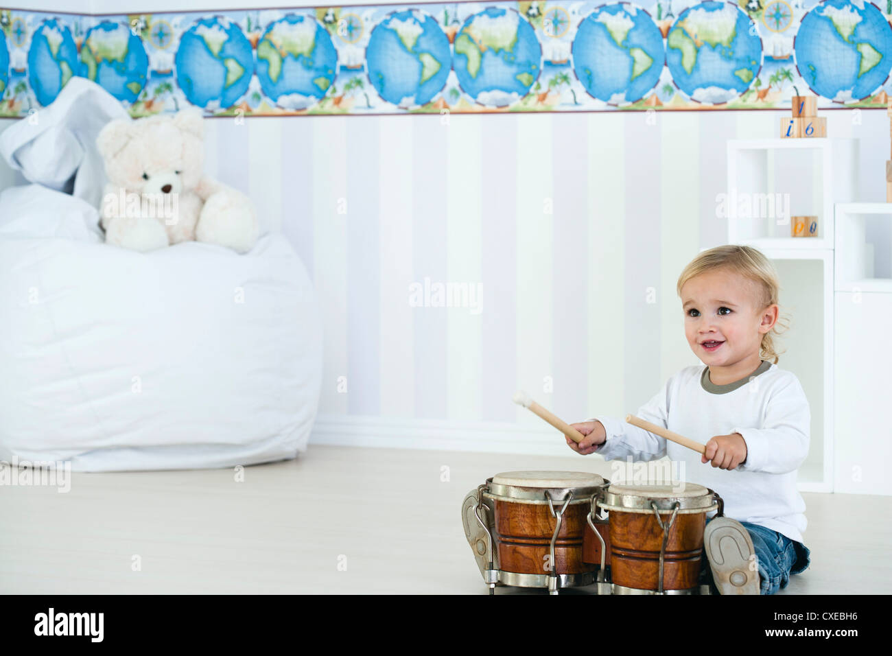 Baby boy playing drums in nursery Stock Photo Alamy