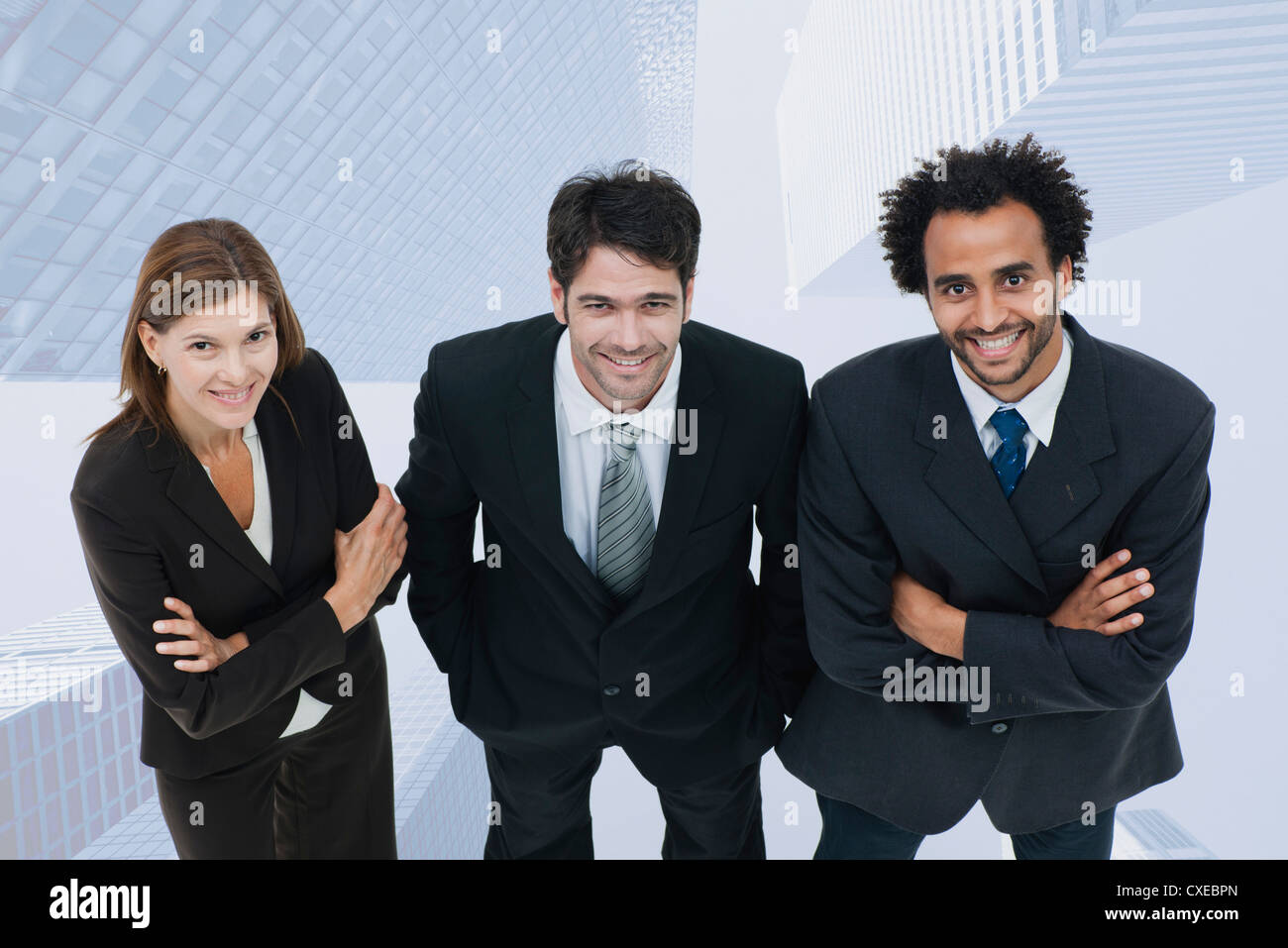 Team of executives smiling confidently with skyscrapers superimposed on background Stock Photo