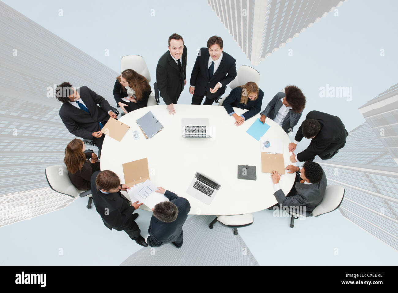 Business executives meeting on top of superimposed image of skyscrapers Stock Photo