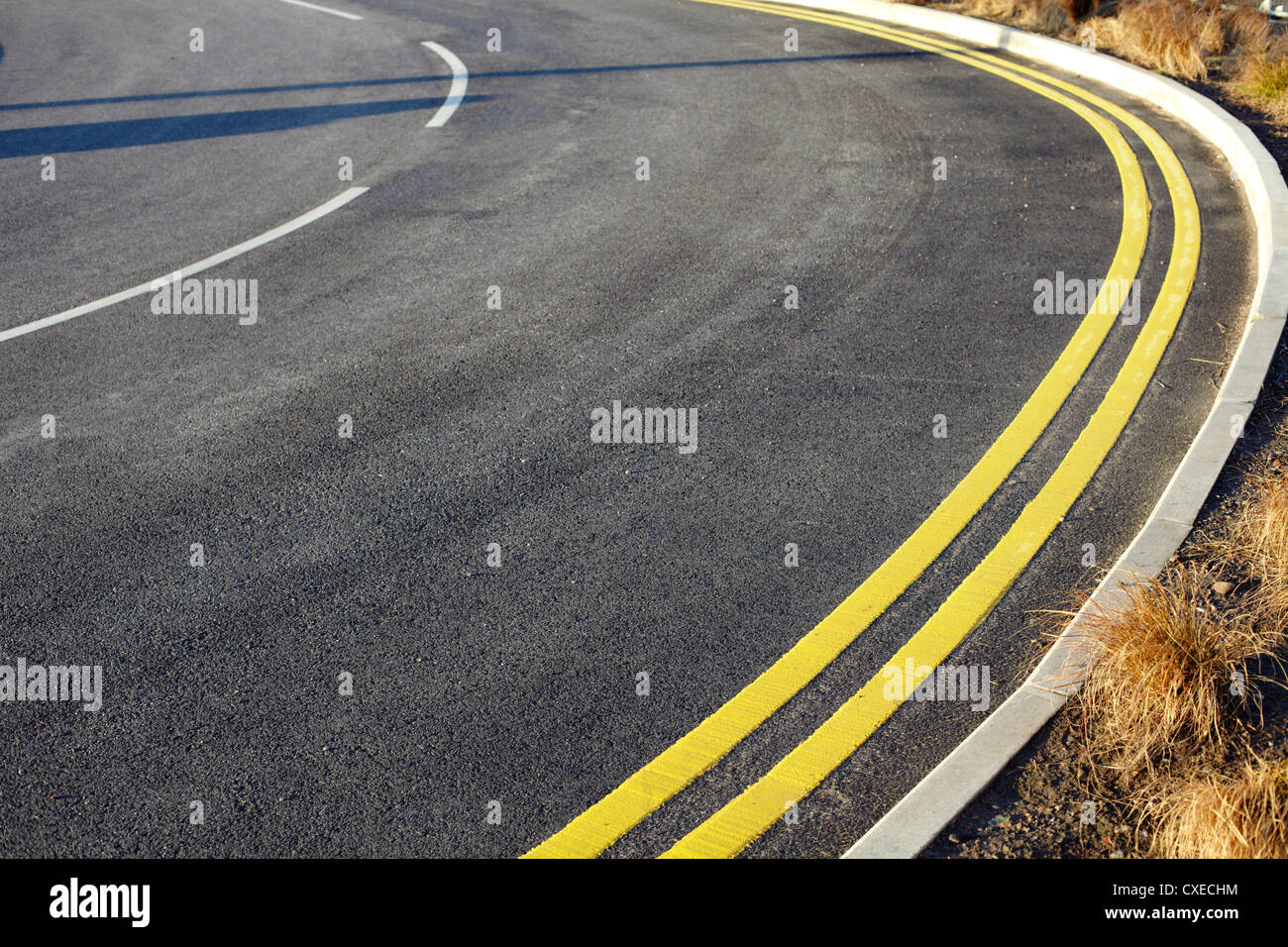 Double yellow lines and a curve in road Stock Photo