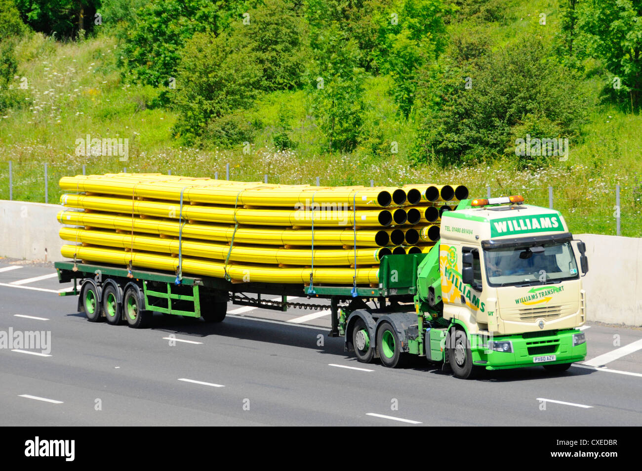 Haulage Contractor lorry and trailer transporting a load of yellow gas pipes Stock Photo
