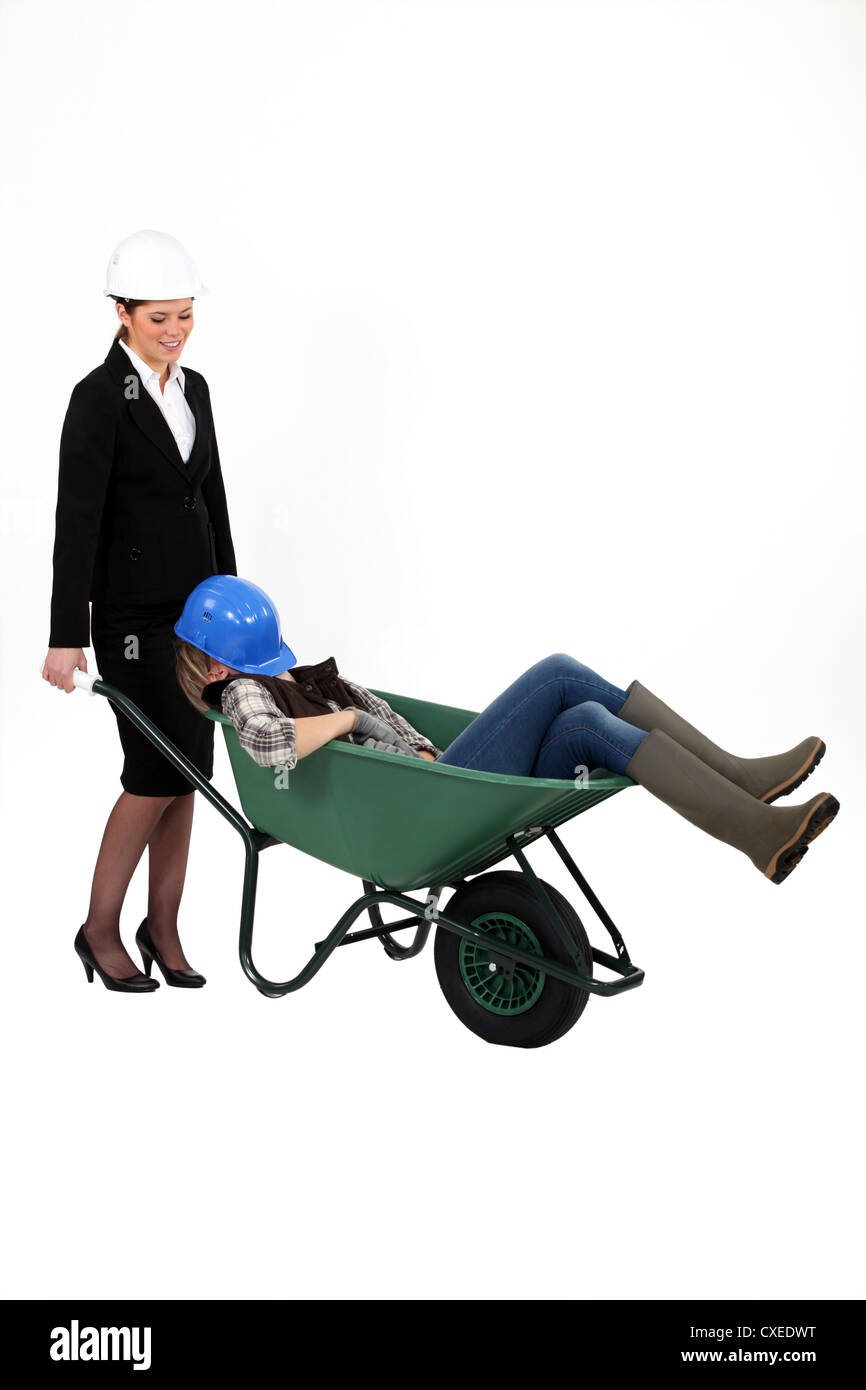 Woman pushing sleepy colleague in a wheelbarrow Stock Photo - Alamy