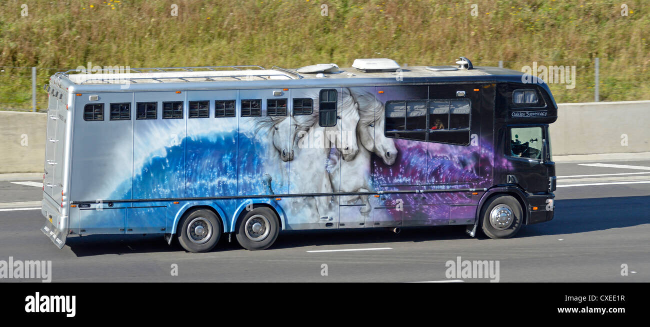 Close up side view of horses graphics on twin rear axle Oakley Supreme  horsebox lorry truck driving on UK motorway England Stock Photo - Alamy