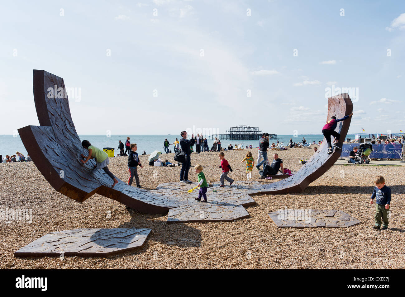 Children playing on the iron sculpture Passacaglia on Brighton beach Stock Photo
