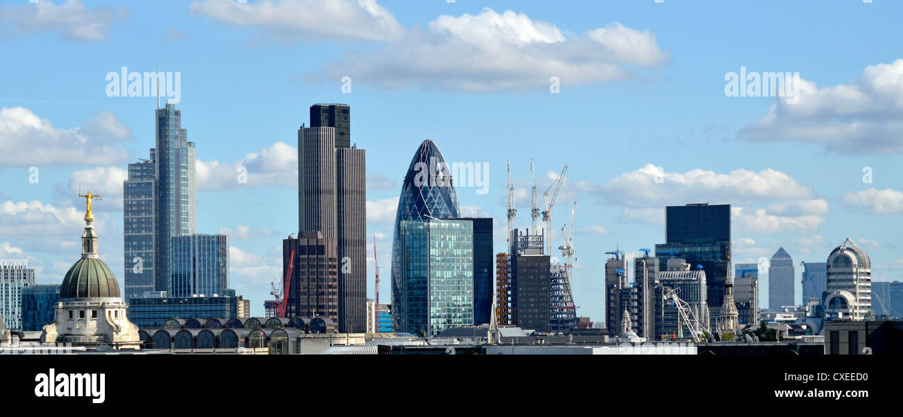 Blue sky sunny day in City of London skyline buildings including Old Bailey Heron Tower Tower 42 Gherkin Lloyds with Canary Wharf distant England UK Stock Photo