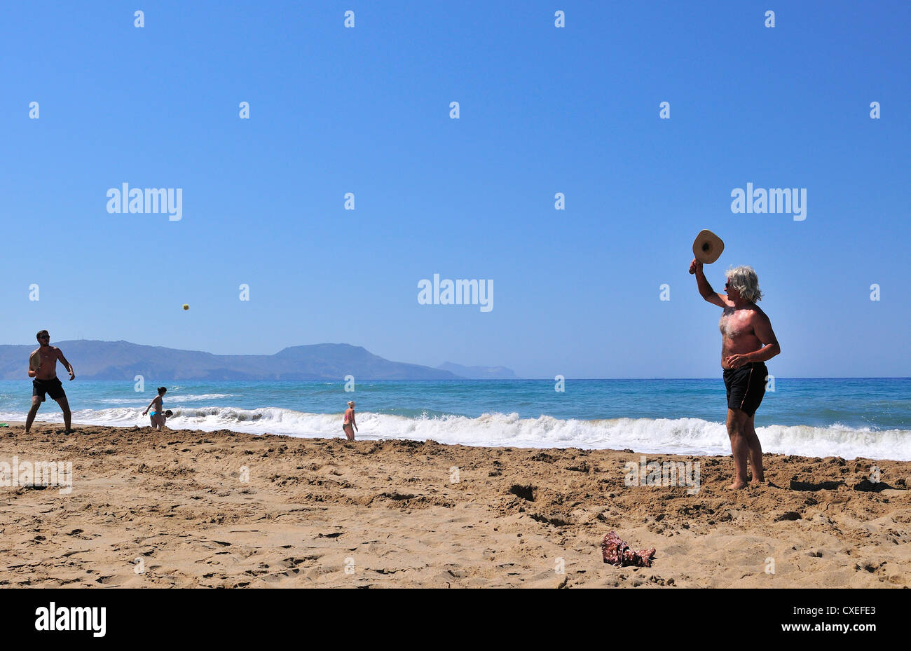 Two men playing  bat and ball.on Paralia  Kouma beach -West ofRethymnon ,  Crete Stock Photo