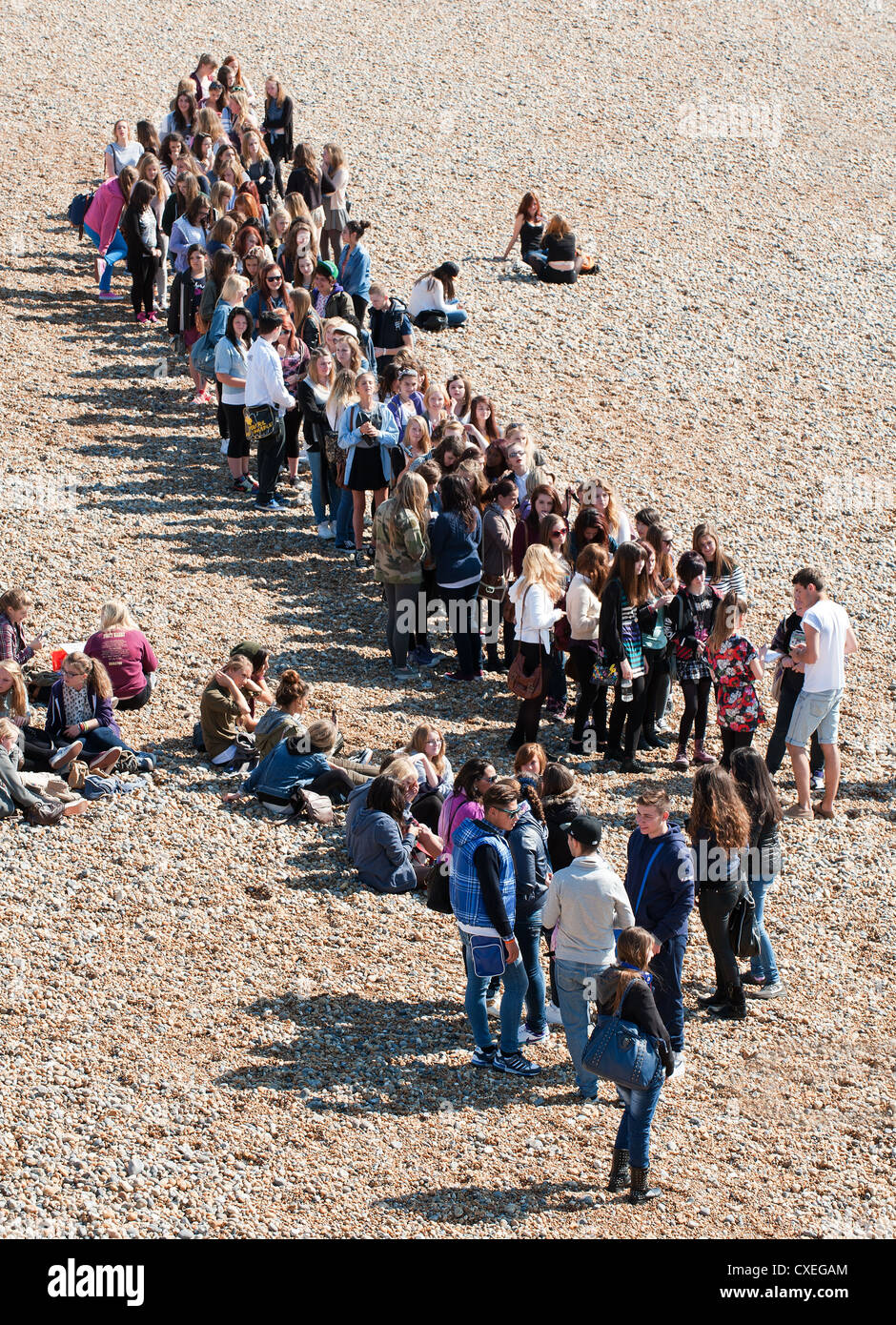 A queue of young people on Brighton beach Stock Photo