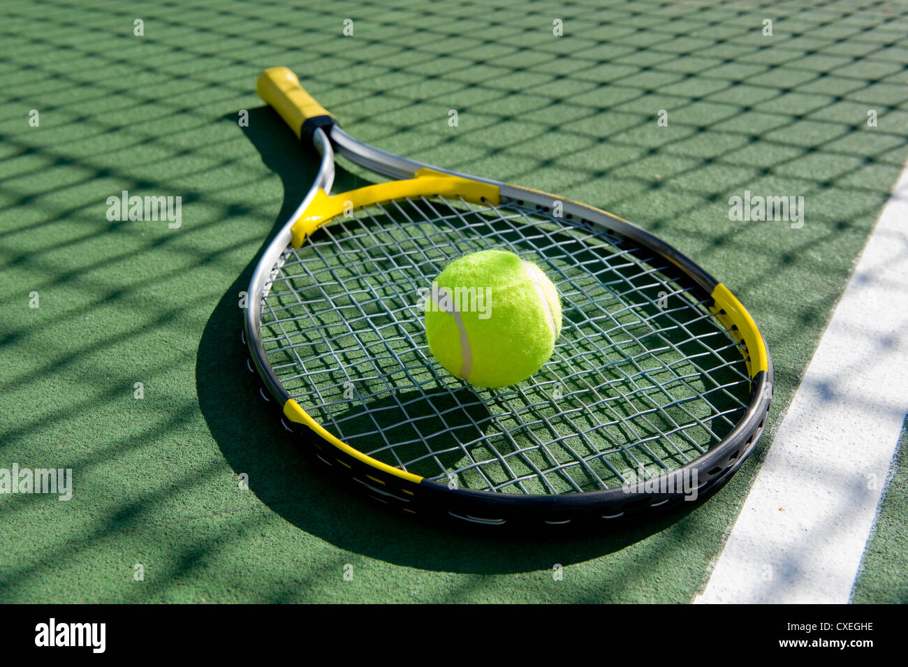 A tennis ball and racket on a freshly painted tennis court Stock Photo