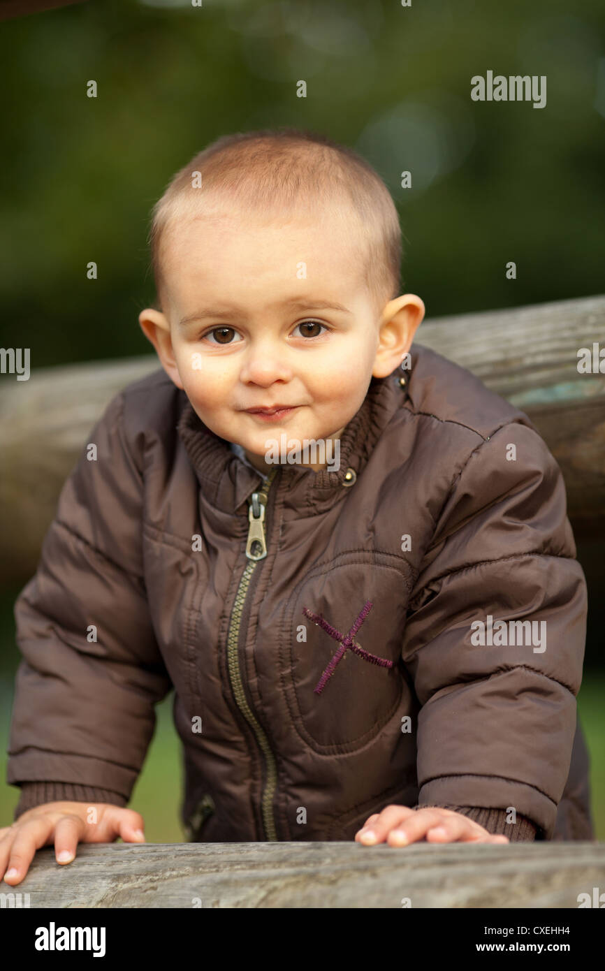 One and a half years old baby boy playing on a wooden fence Stock Photo ...