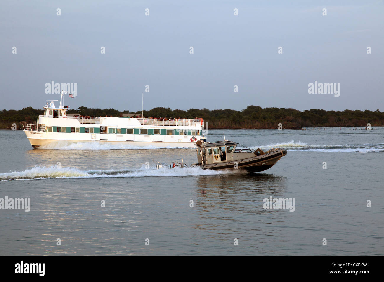 Fire Island Ferry passing Harbor Police boat, Great South Bay, NY, USA Stock Photo