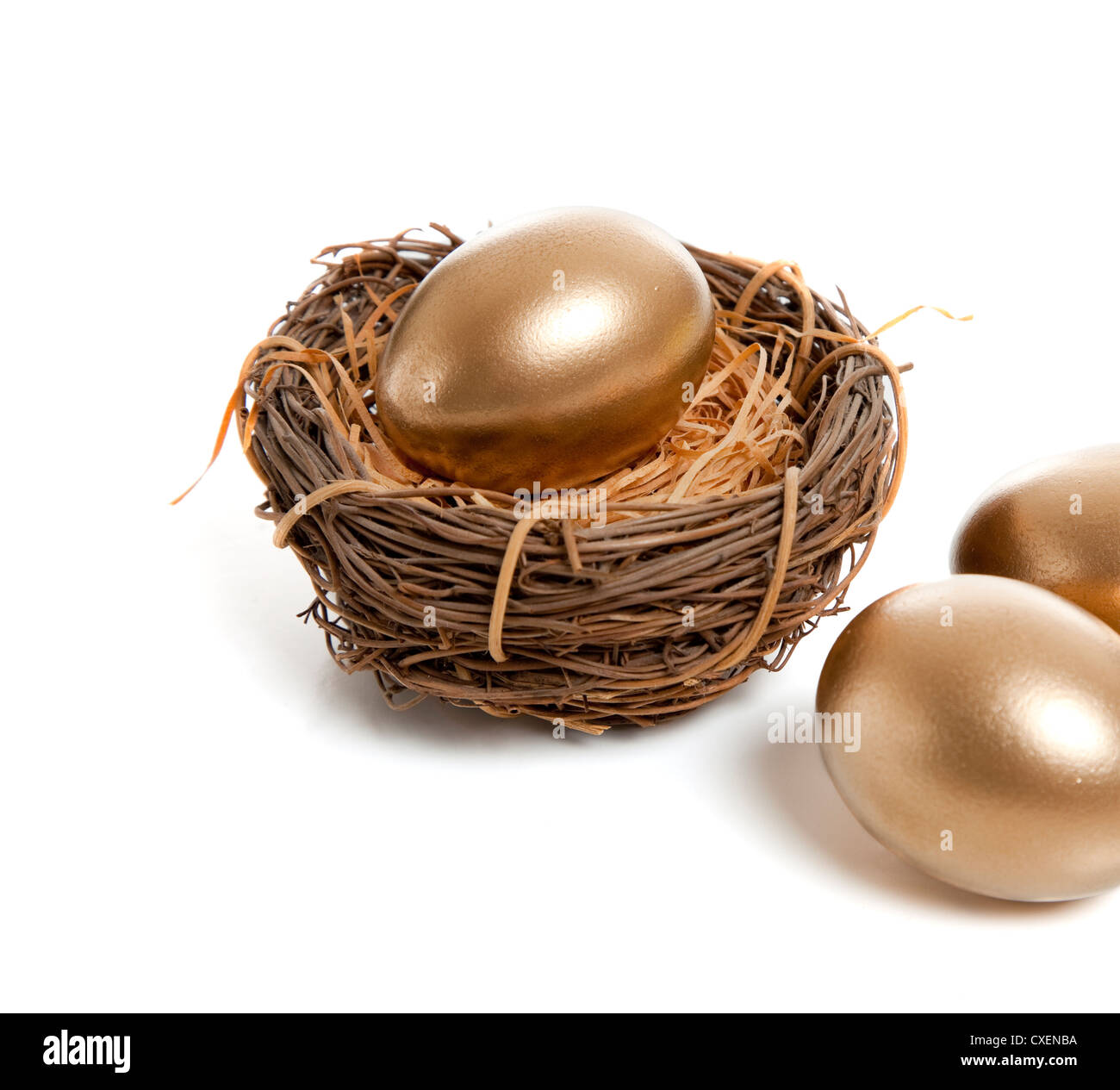 A golden egg in a birds nest on a white background Stock Photo - Alamy