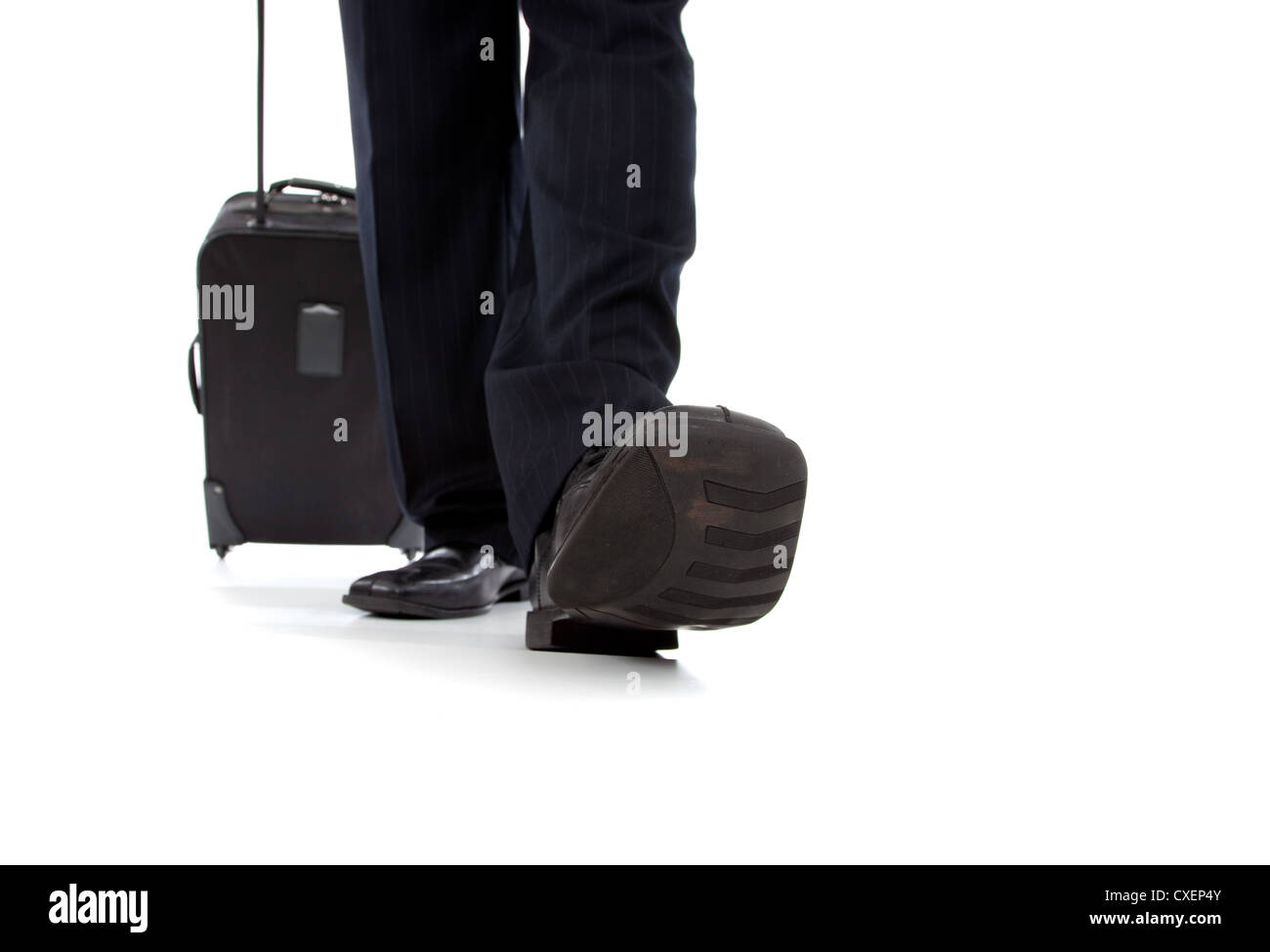 The feet and legs of a business man with a suitcase behind him Stock Photo
