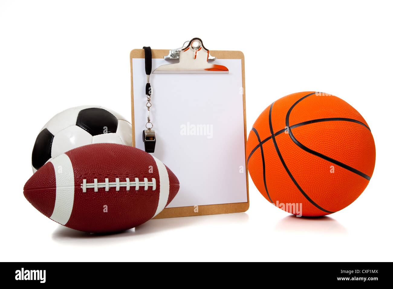 Coach's clipboard and whistle with a football, basketball and soccer ball Stock Photo
