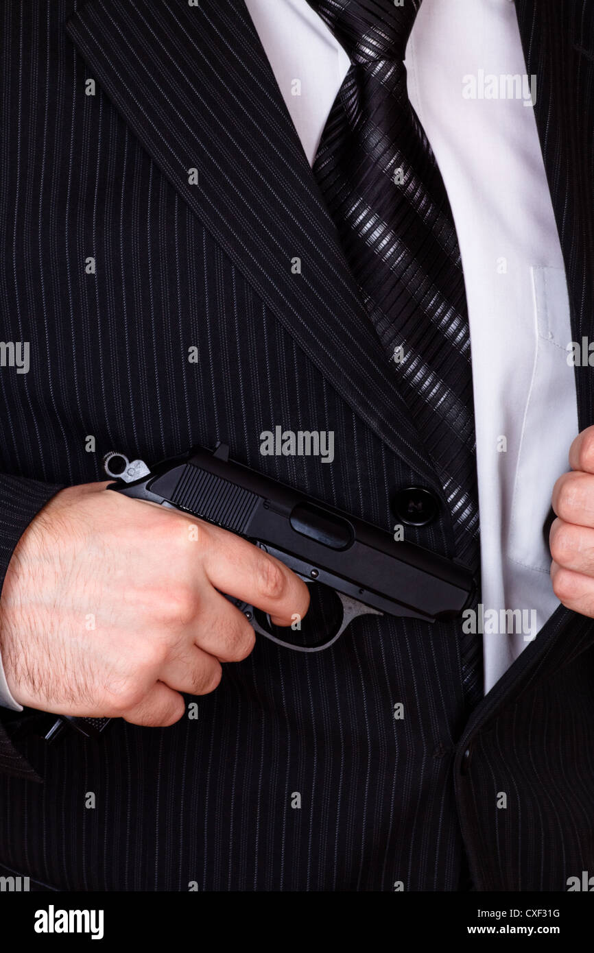 man drawing his gun from jacket pocket Stock Photo Alamy