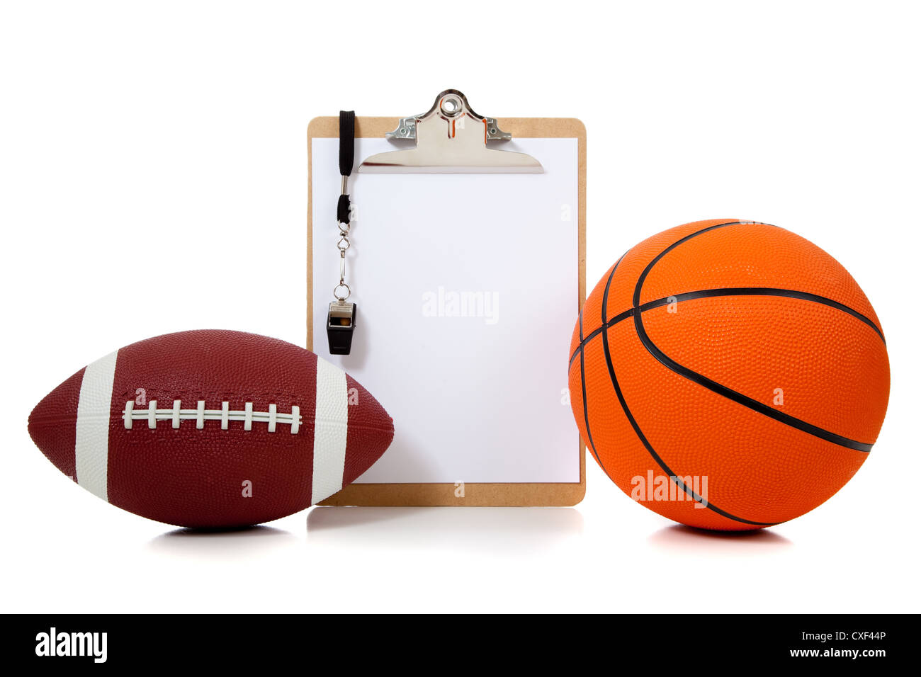 Coach's clip board with whistle basketball and an American football Stock Photo