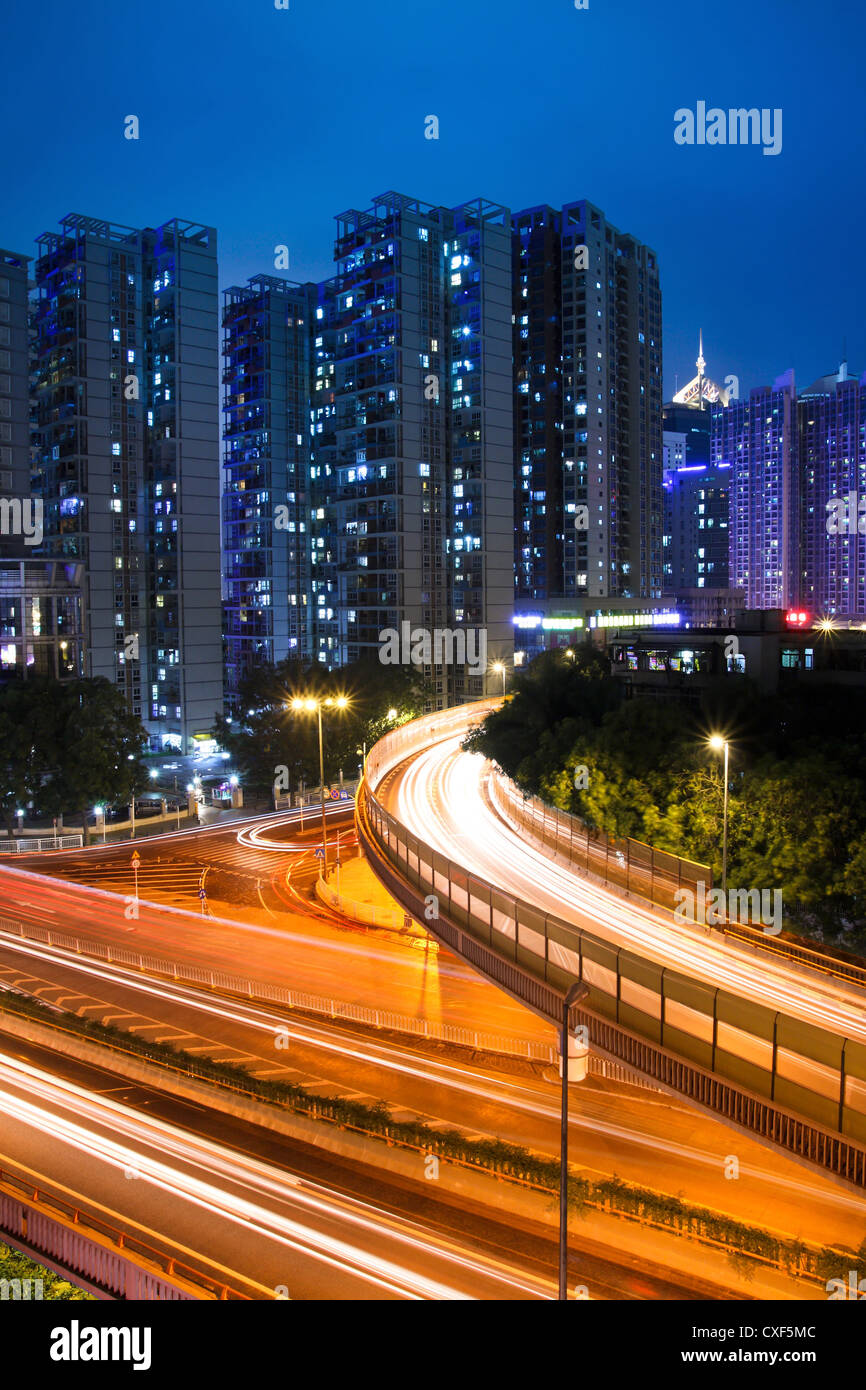 light trails on the viaduct in bustling city at night Stock Photo