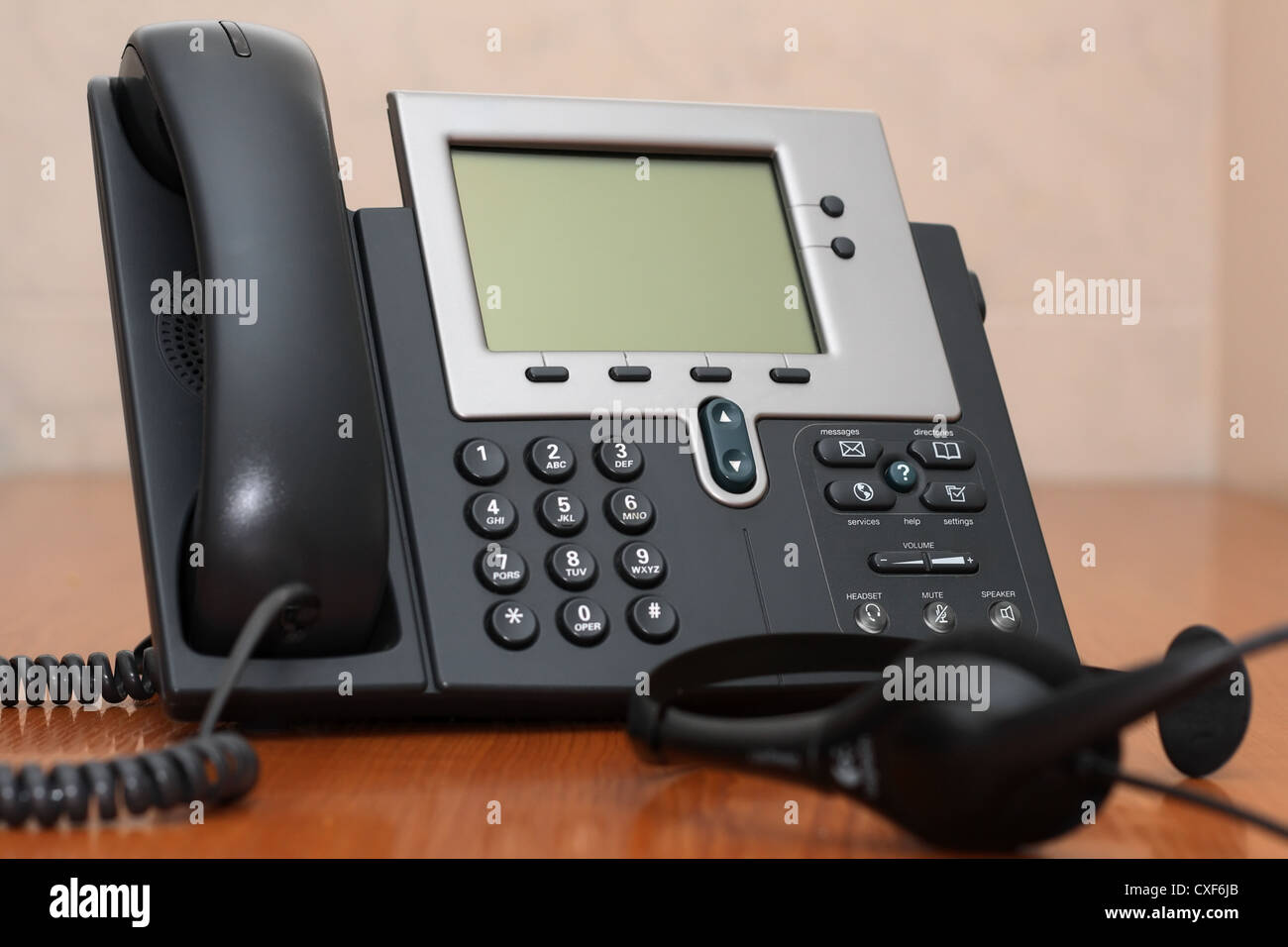 IP Phone close-up view with blurred headset on foreground Stock Photo