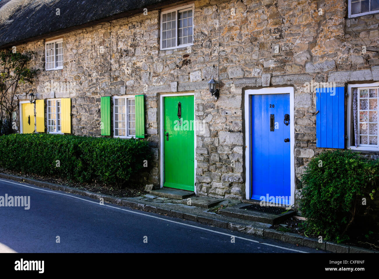 Yellow Green And Blue Doors And Shutters On A Row Of Cottages In
