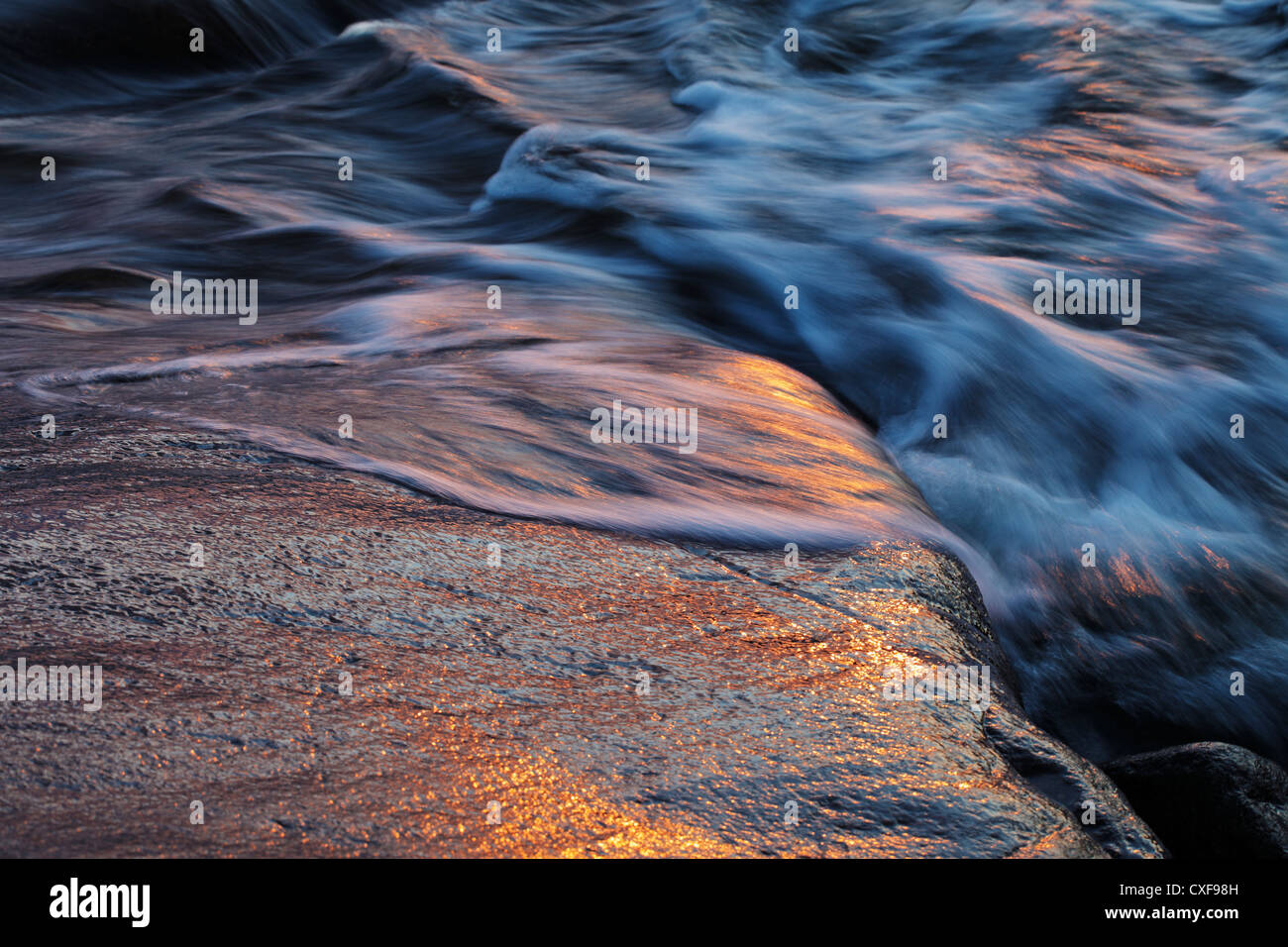 Sea waves on a rock in evening light. Stock Photo
