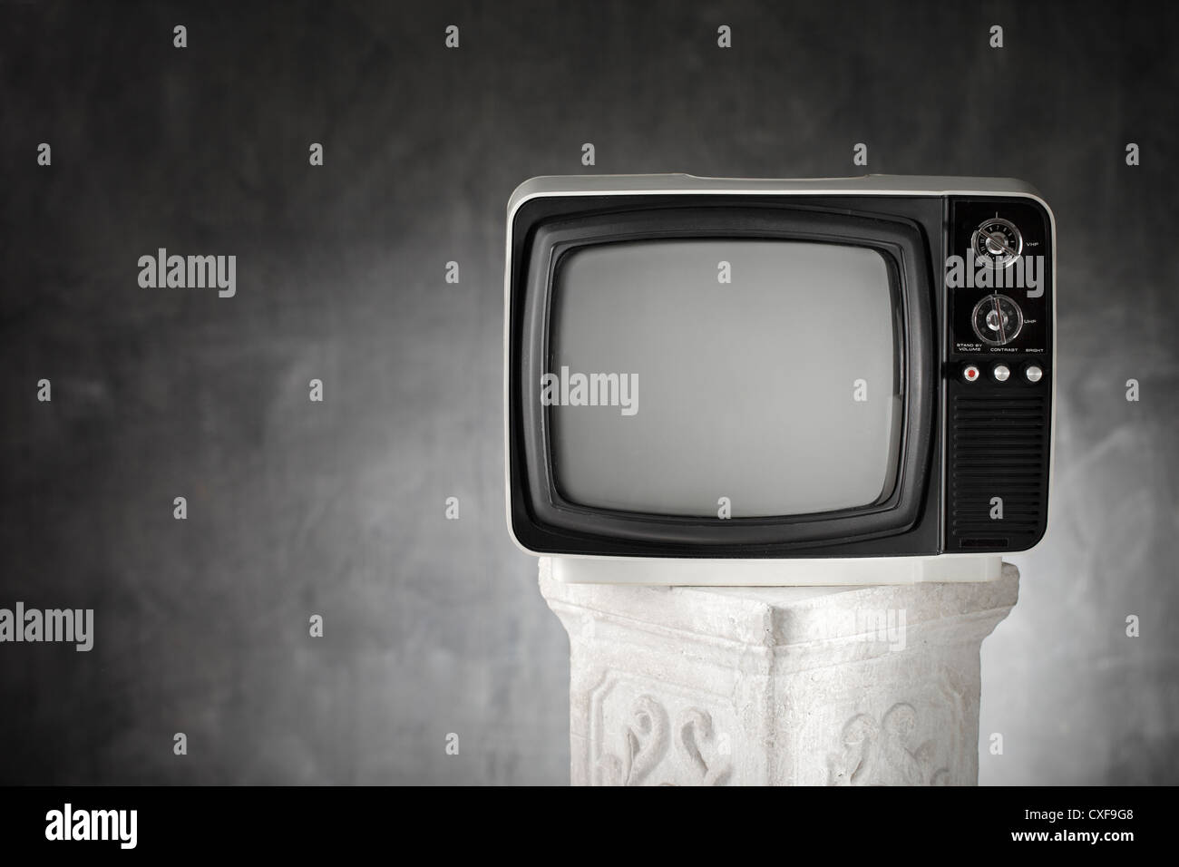 Old portable television on a plaster column. Stock Photo