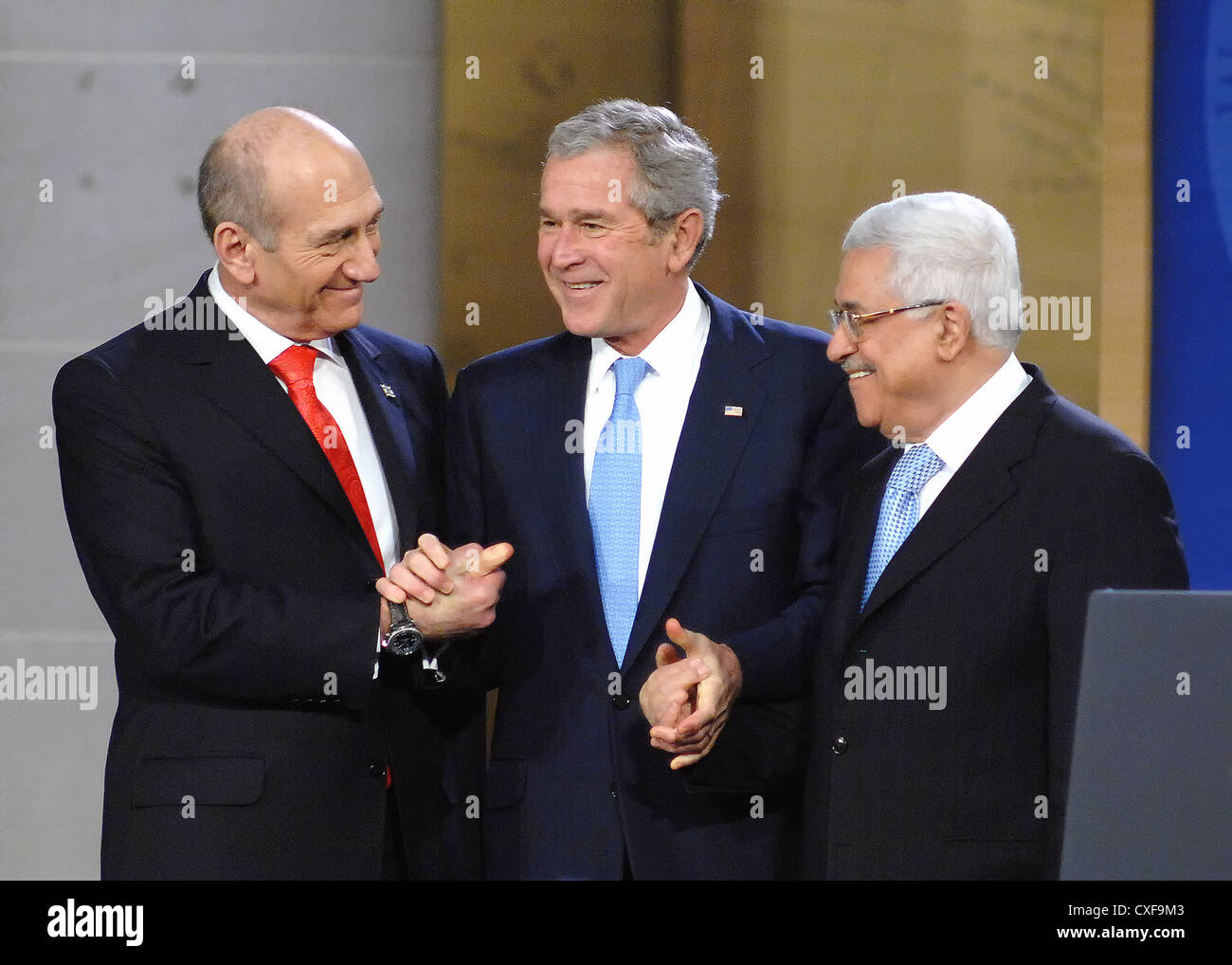 US President George W. Bush shakes hands with Israeli Prime Minister Ehud Omert (L) and Palestinian President Mahmoud Abbas following his address at the Annapolis Conference November 27, 2006 in Annapolis, Maryland. Stock Photo