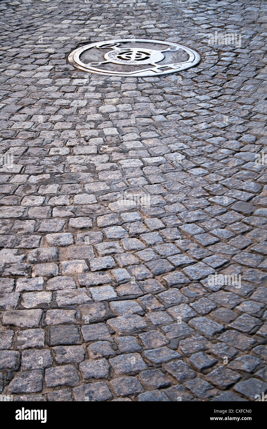 Cobble walkway with sewer cover as background Stock Photo