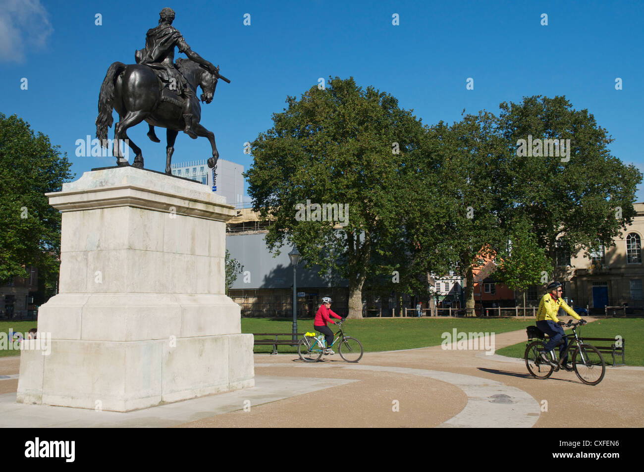 Cyclists passing William III statue Queen Square Bristol Stock Photo