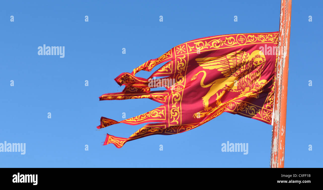 Detail of Venetian flag against blue sky Stock Photo