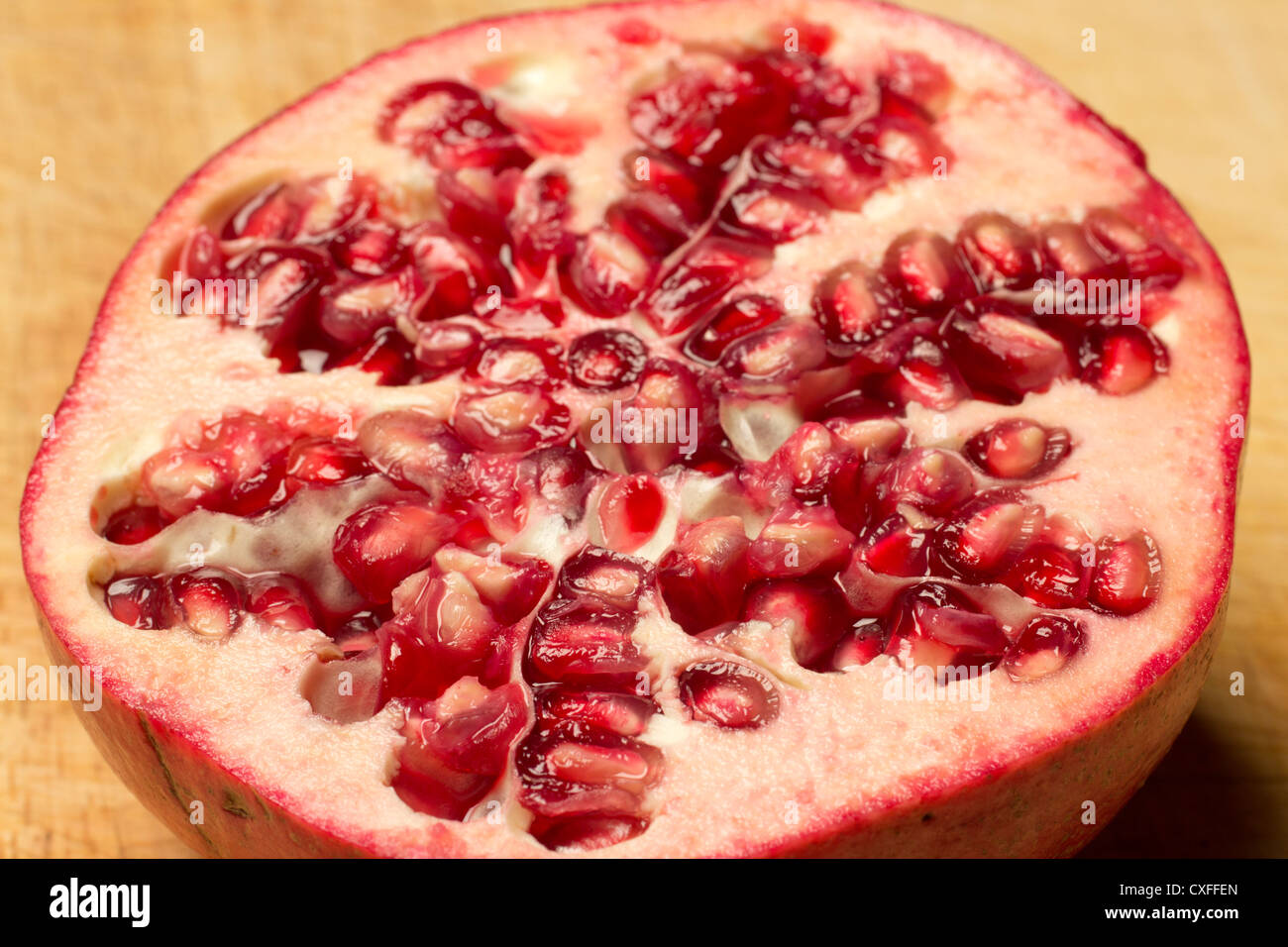 A Pomegranate sliced open to reveal the seeds. Stock Photo