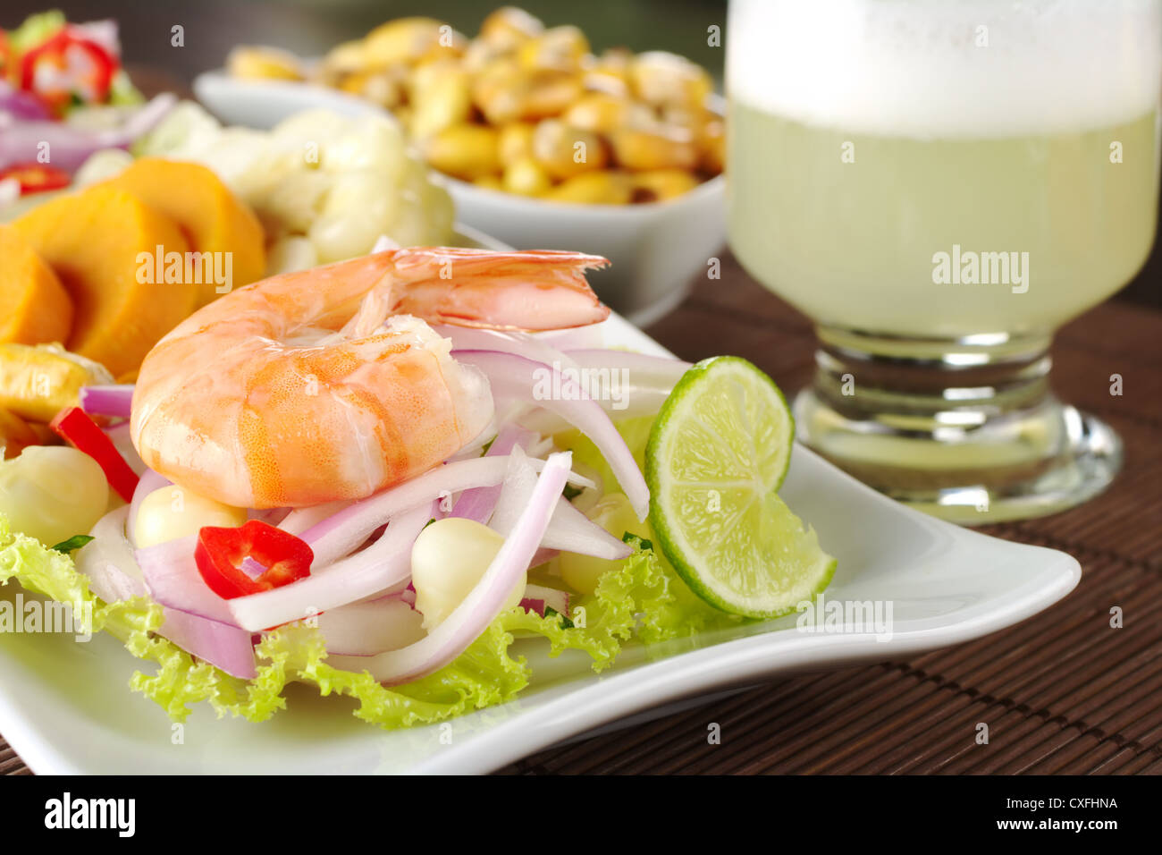 Peruvian king prawn ceviche with sweet potatoes, corn, cancha (fried corn) and the Peruvian cocktail called Pisco Sour Stock Photo