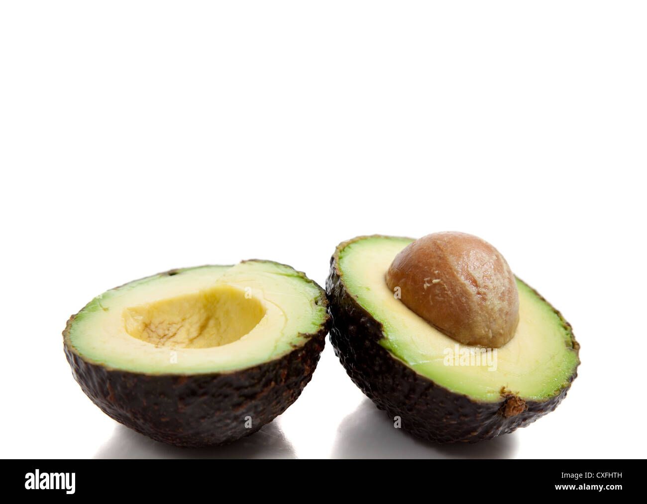 An avocado cut in half with seed on a white background Stock Photo - Alamy